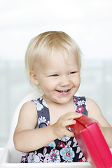 Image showing Little girl gleefully opening Christmas gifts.