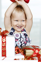 Image showing Little girl gleefully opening Christmas gifts.