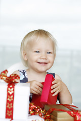 Image showing Little girl gleefully opening Christmas gifts.