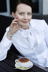 Image showing Portrait of a beautiful business woman with a cappuccino.