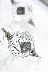 Image showing Sparkly silver colored Christmas baubles on glass table.