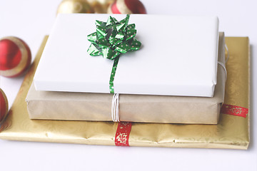 Image showing Three simply wrapped Christmas gifts with decorations.