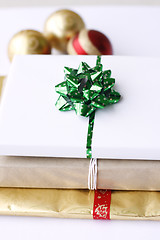 Image showing Three simply wrapped Christmas gifts with decorations.