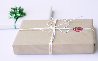 Image showing Two simply wrapped gifts with decorations.