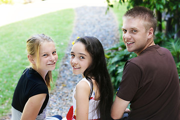 Image showing Portrait of three happy adolescents together outdoors.