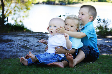 Image showing Three happy brothers together outdoors.