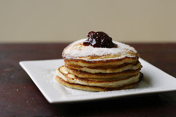 Image showing Stack of pancakes with honey and jam.