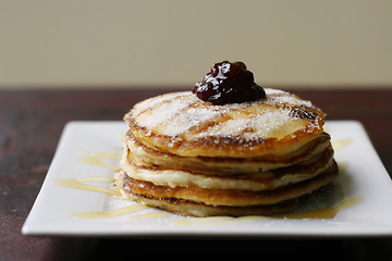 Image showing Stack of pancakes with honey and jam.