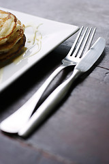 Image showing Knife and fork next to a stack of pancakes.