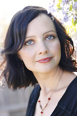 Image showing Portrait of a beautiful woman with blue eyes wearing a black out