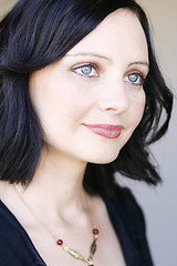 Image showing Portrait of a beautiful woman with blue eyes wearing a black out