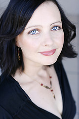 Image showing Portrait of a beautiful woman with blue eyes wearing a black out