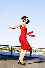 Image showing Beautiful woman in a red dress outdoors.