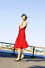 Image showing Beautiful woman in a red dress outdoors.