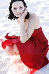 Image showing Portrait of a beautiful woman in a red dress outdoors.