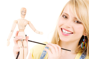 Image showing happy teenage girl with wooden model dummy