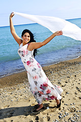 Image showing Beautiful young woman at beach with white scarf