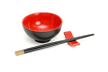 Image showing Chopsticks on stand and red and black Japanese bowl isolated