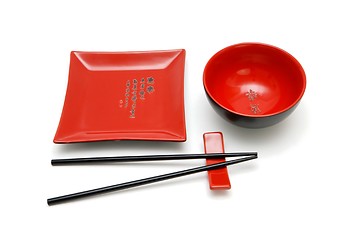 Image showing Square red plate, round bowl and chopsticks on stand isolated