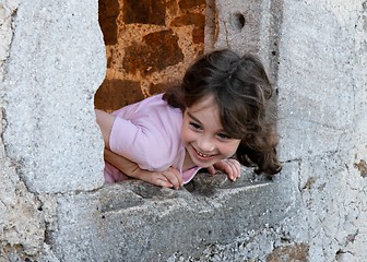 Image showing Smiling girl leans out of the castle window