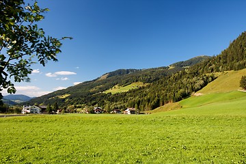 Image showing Alpine chalets and meadows under the mountains