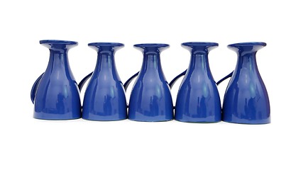 Image showing Row of five blue coffee cups upside down isolated