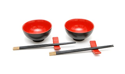 Image showing wo sets of chopsticks and red and black Japanese bowls isolated