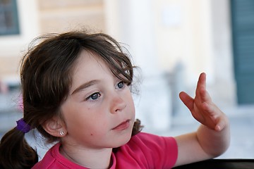 Image showing Cute serious seven years girl gestures with her hand