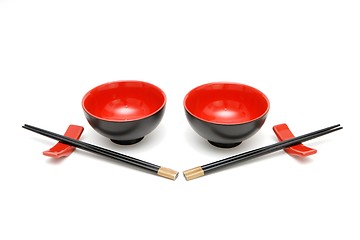 Image showing Two sets of chopsticks and red and black Japanese bowls isolated 