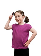 Image showing Cute seven years girl with pigtails brush her hair isolated