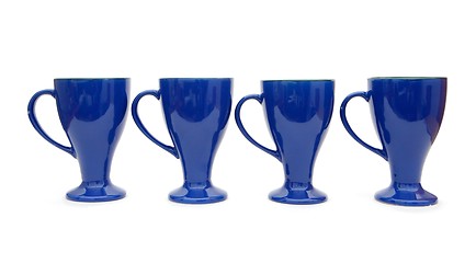 Image showing Row of four blue high coffee cups isolated