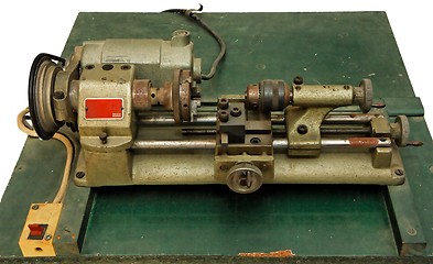 Image showing Small metal lathe on green board isolated 