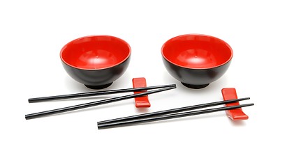 Image showing Two sets of chopsticks and red and black Japanese bowls isolated