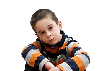 Image showing Serious cute little five year old boy sits  isolated