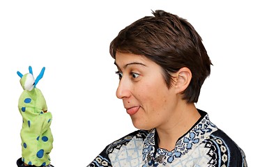 Image showing Woman sticks out her tongue to a glove puppet isolated