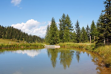 Image showing Trees and clouds reflecting in the pond