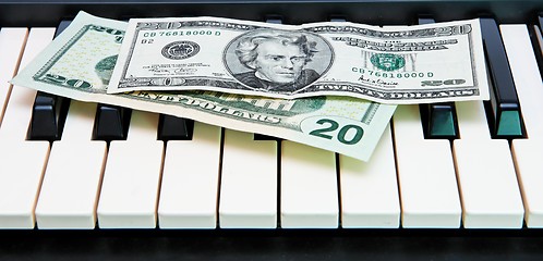 Image showing Two twenty dollar bills on electric organ keyboard