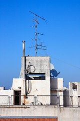 Image showing Old television aerial on house roof against blue sky