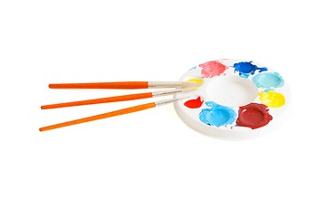 Image showing Round kids palette with three paintbrushes isolated