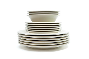 Image showing Stack of plain beige dinner and soup plates and saucers isolated