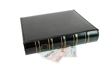 Image showing Thick black book on euro bills isolated