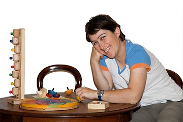 Image showing Smiling woman plays with wooden toys isolated