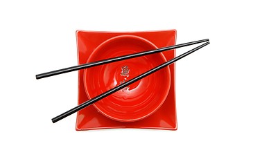 Image showing Black chopsticks on red Japanese bowl  and square plate top view isolated