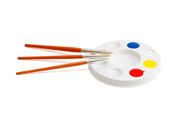 Image showing Round kids palette with three paintbrushes isolated