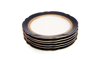 Image showing Stack of dark-blue dinner plates with a golden rim isolated