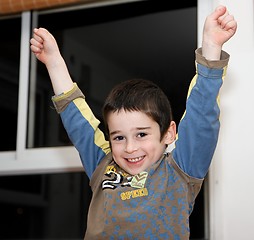 Image showing Cute little boy rises his arms in a V-sign
