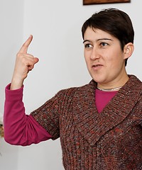Image showing Young short-haired woman raising her finger