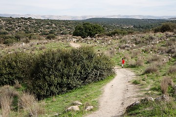Image showing Lonely little boy walks along the trail among hills outdoor