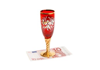 Image showing Beautiful red wine glass on ten euro bill isolated 