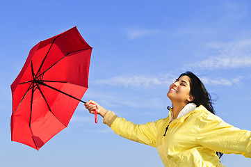 Image showing Beautiful young woman in raincoat with umbrella